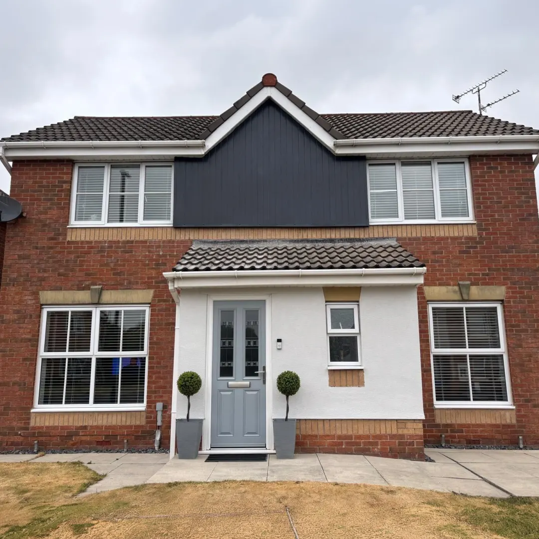 Grey composite front door and white windows fitted by Newlook on a North West home